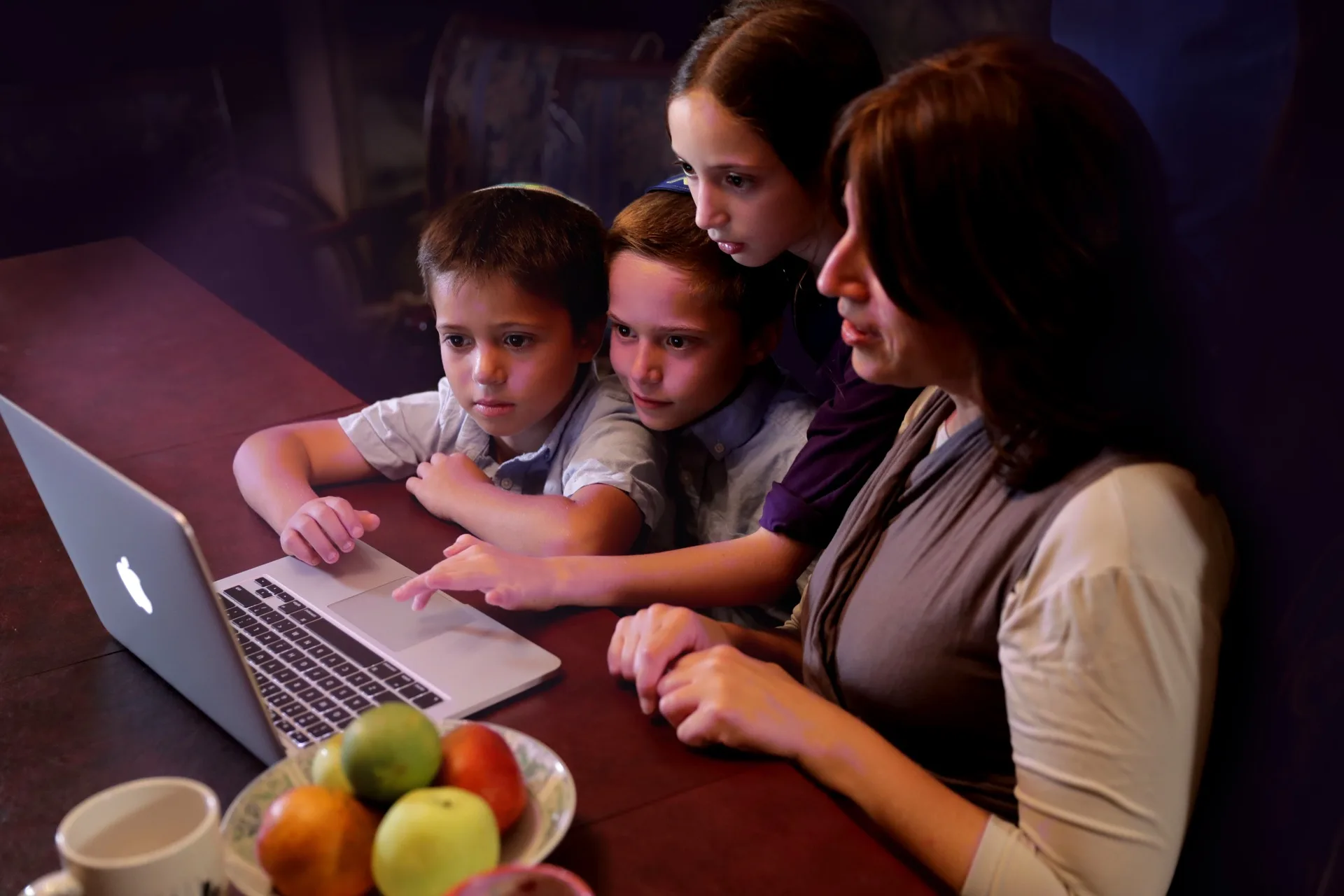 A mother and three children watching Torah Live together at home