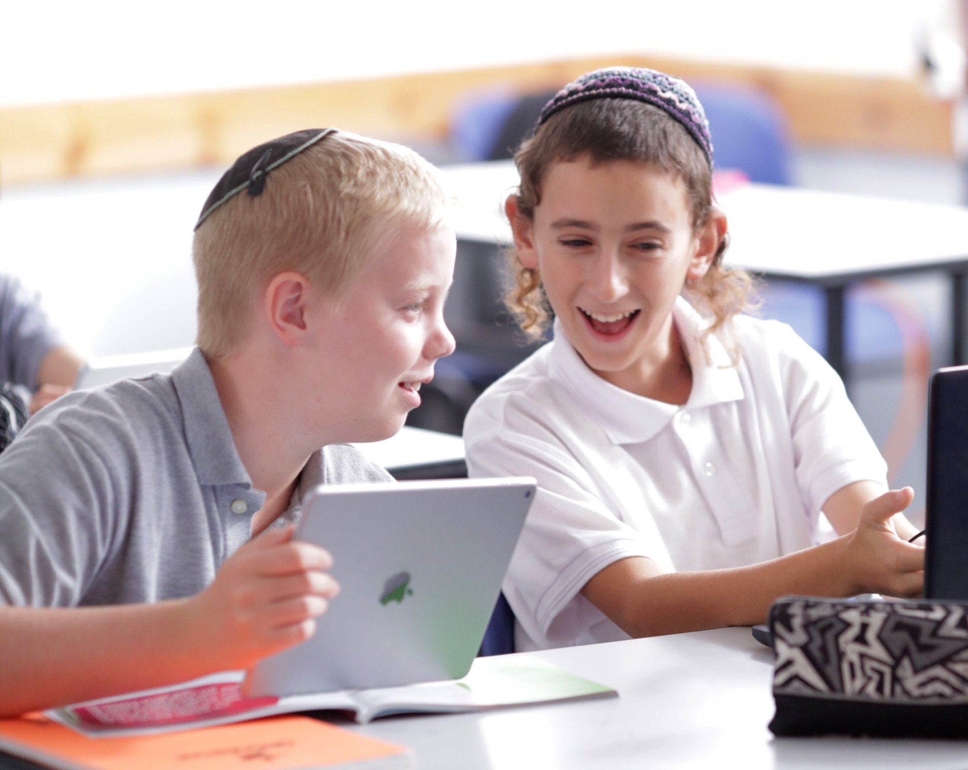 Two boys laughing together at a Torah Live video