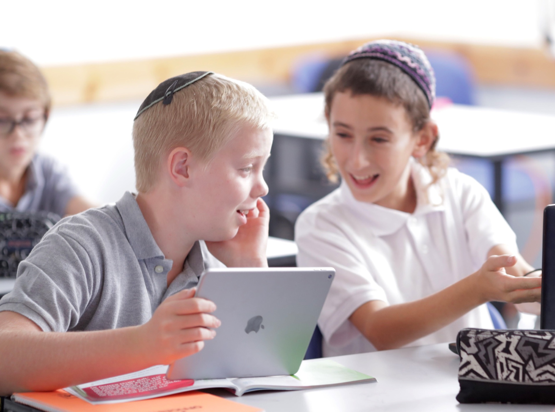 Two students smiling at a Torah Live video